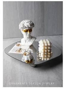 Acrylic irregular mirror jewelry tray photo display prop with artistic bust and candle decor.