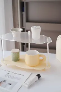 Detail view of a minimalist 2-tier cloud acrylic desktop storage rack for cosmetics and cups.