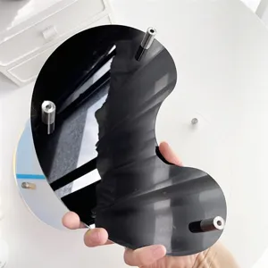 Detail view of the crescent acrylic display tray, showing smooth black surface and pillars.