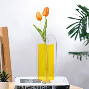 Creative minimalist acrylic vase with artificial tulips, modern transparent geometric desktop decor ornament.