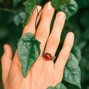 Detailed close-up of a Thai silver ring featuring an amber gemstone and floral carved band.