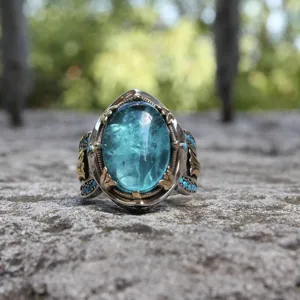 Bague vintage avec pierre bleue et gravures filigranes en métal bicolore élégant.