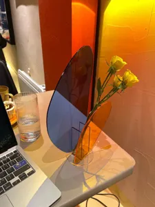 Modern geometric acrylic flower vase with yellow roses, clear decorative home table decor.