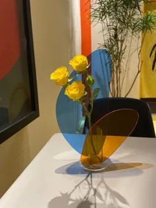 Modern geometric acrylic vase with colorful transparent panels for stylish home and living room decor.