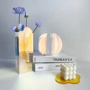 Vista dettagliata di moderni vasi in acrilico iridescente con papaveri artificiali.