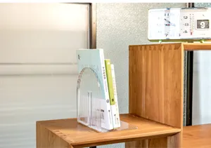 Clear acrylic bookend detail shot, minimalist L-shaped desktop book organizer for shelf.