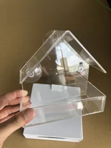 Detalle de comedero para pájaros de acrílico transparente, dispensador colgante.