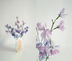Detailansicht einer modernen Acryl-Vase mit künstlichen Blumen für kreative Inneneinrichtung.