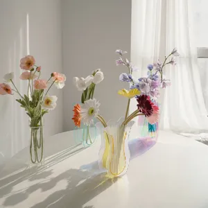 Moderne transparente Acryl-Faltvase mit bunten künstlichen Blumen für Tischdekoration