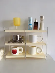 Vista detallada del estante de escritorio acrílico con tazas y frascos ordenados.