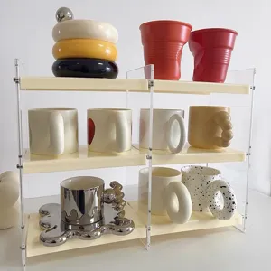 Estante de almacenamiento de escritorio de acrílico transparente con tazas de cerámica.