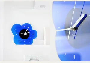 Close-up detail of modern Klein blue acrylic flower wall clock with silent quartz movement.