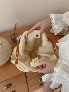 Vista dettagliata della borsa tote in paglia estiva interno con fodera e bottone.