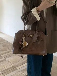 Retro brown shoulder handbag for women, large capacity commuter tote bag with stylish charms.