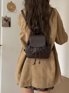 Mini brown leather backpack detail showcasing drawstring closure and compact everyday style.
