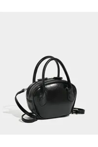 Close-up detail view of black glossy bowling bag, sleek shell shape with top handles.