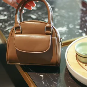 Brown retro dome handbag for women, chic PU leather crossbody bag with front pocket detail.