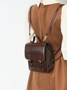 Détail mini sac à dos en cuir style collège rétro, petit sac bandoulière marron pour femmes.
