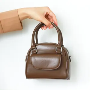 Brown PU leather mini handbag detail showcasing front flap pocket and silver hardware.