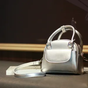 Detailed close-up view of the trendy silver shell handbag showcasing its unique texture and metal hardware.