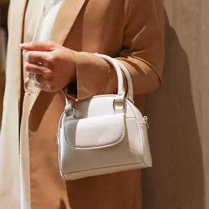 Detailed shot of white top handle handbag with front flap pocket and daily style.