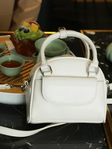 Chic white dome handbag for women, versatile PU leather crossbody bag with top handle.