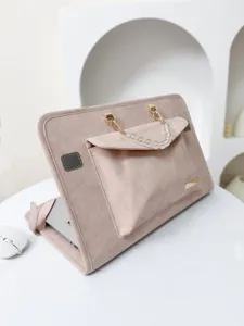 Vista dettagliata della custodia per laptop rosa, con manico di perle e tasca frontale.