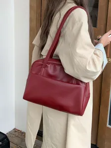 Detailansicht der eleganten roten Ledertasche mit feiner Textur und praktischer Vordertasche.