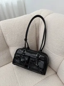 Detailansicht der schwarzen glänzenden Lederschultertasche mit schicken Schleifentaschen.