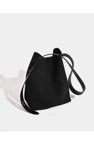 Detail schwarze Wildleder Beuteltasche, minimalistischer Einzelriemen, elegante Alltagstasche.