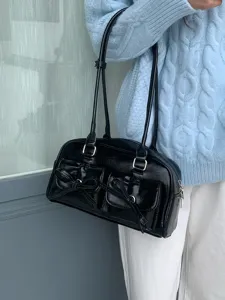 Detailansicht der schwarzen Glanz-Schultertasche mit Schleifentaschen und Riemen.