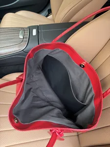 Detailed view of the large red leather tote bag interior, showing grey lining and capacity.