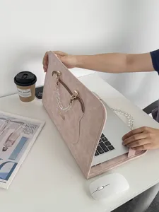 Detailansicht der rosa Leder Laptoptasche mit Perlenketten Griff auf weißem Schreibtisch.