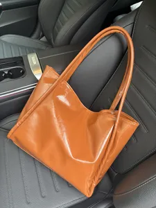 Glossy brown PU leather tote bag close-up detail showcasing soft texture and stylish car scene.