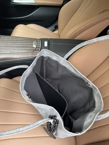 Detail view of a large capacity soft leather tote bag with dark chain strap and insert.
