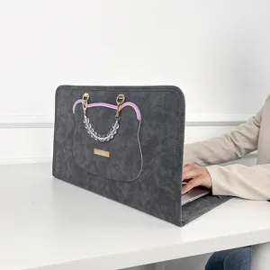 Detailansicht der dunkelgrauen Laptoptasche mit süßem Bärenmotiv, Perlenhenkel und Plakette.