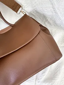Detailaufnahme der braunen Damen Umhängetasche mit breitem Gurt und hochwertigen Beschlägen.