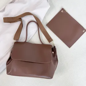 Braune Damenhandtasche Detail, große Umhängetasche mit breitem Gurt und passender Tasche.