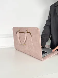 Vue rapprochée détaillée de la housse d'ordinateur en cuir rose avec poignée élégante.