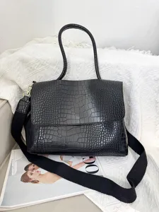 Große schwarze Handtasche mit Krokodilmuster und breitem Gurt für Damen im Alltag.