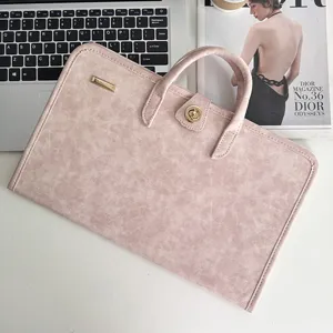 Detailed close-up of pink PU leather laptop sleeve featuring chic metal lock and sturdy handle.