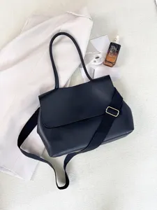 Detailaufnahme einer schwarzen Pendler-Umhängetasche mit breitem Gurt und eleganter Textur.