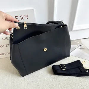 Detailansicht der schwarzen Damen Pendler Shopper Tasche mit goldenen Beschlägen und Gurt.
