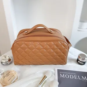 Brown quilted cosmetic bag with top handle and zipper closure for travel and storage.