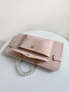 Dettaglio custodia per laptop rosa, con manico di perle trasparenti e tasca frontale.