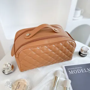 Detailed view of brown quilted cosmetic bag, premium PU leather with double zipper and handle.