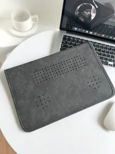 Graue PU Leder Laptop-Hülle Nahaufnahme mit Belüftungslöchern auf minimalistischem Schreibtisch.