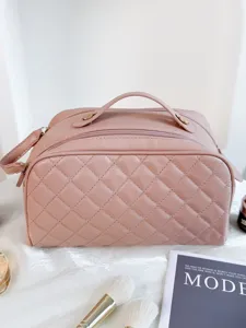 Pink quilted cosmetic bag, portable travel toiletry organizer with secure zipper closure.