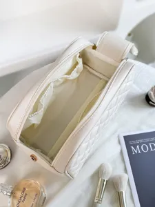 Portable quilted travel cosmetic bag with large capacity zipper closure for women makeup storage.