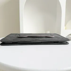 Graue Laptoptasche Detailansicht, minimalistisches Design mit rosa Zierrand und Logo.